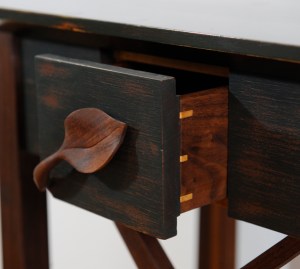 Drawer with hand-carved leaf handle.